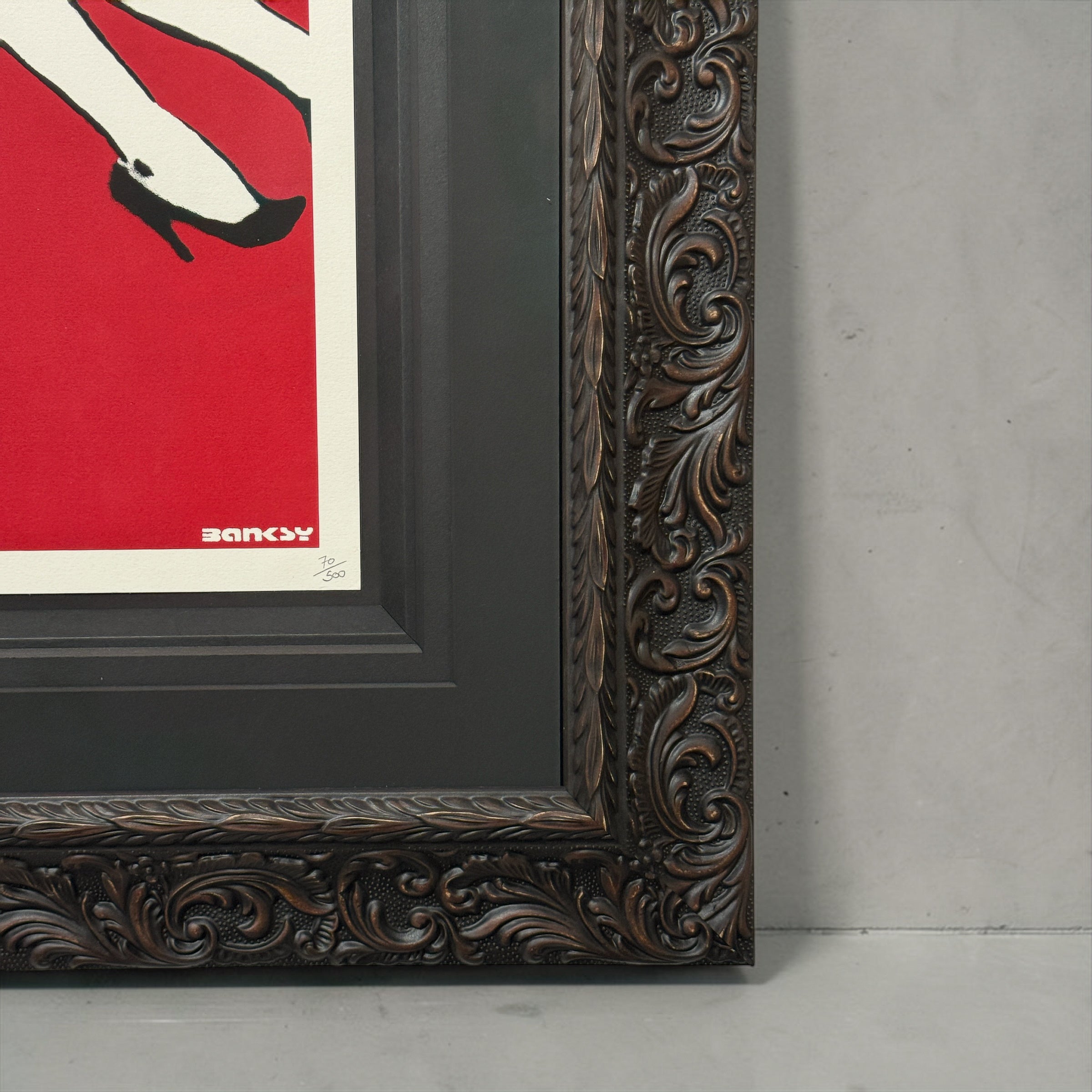 Framed artwork with ornate brown frame and red background