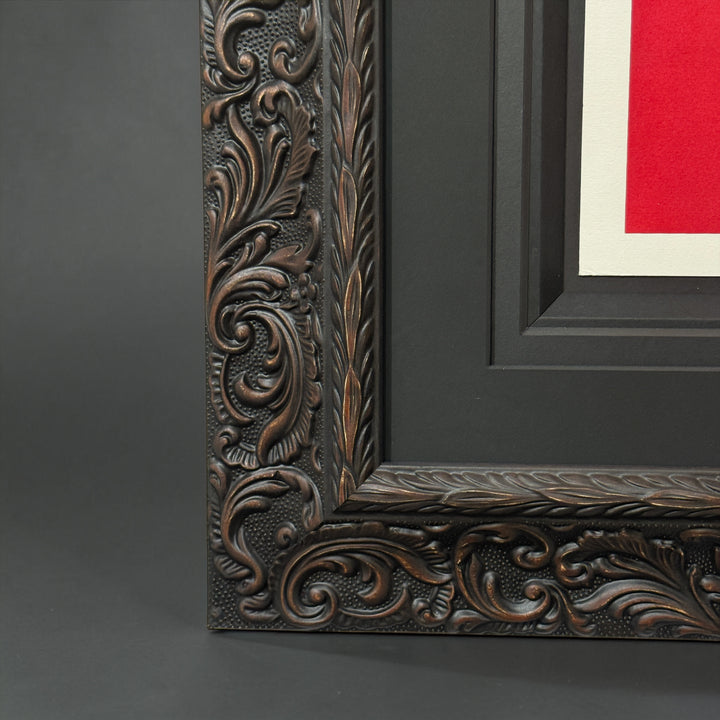 Close-up of an ornate dark wood picture frame on a gray background