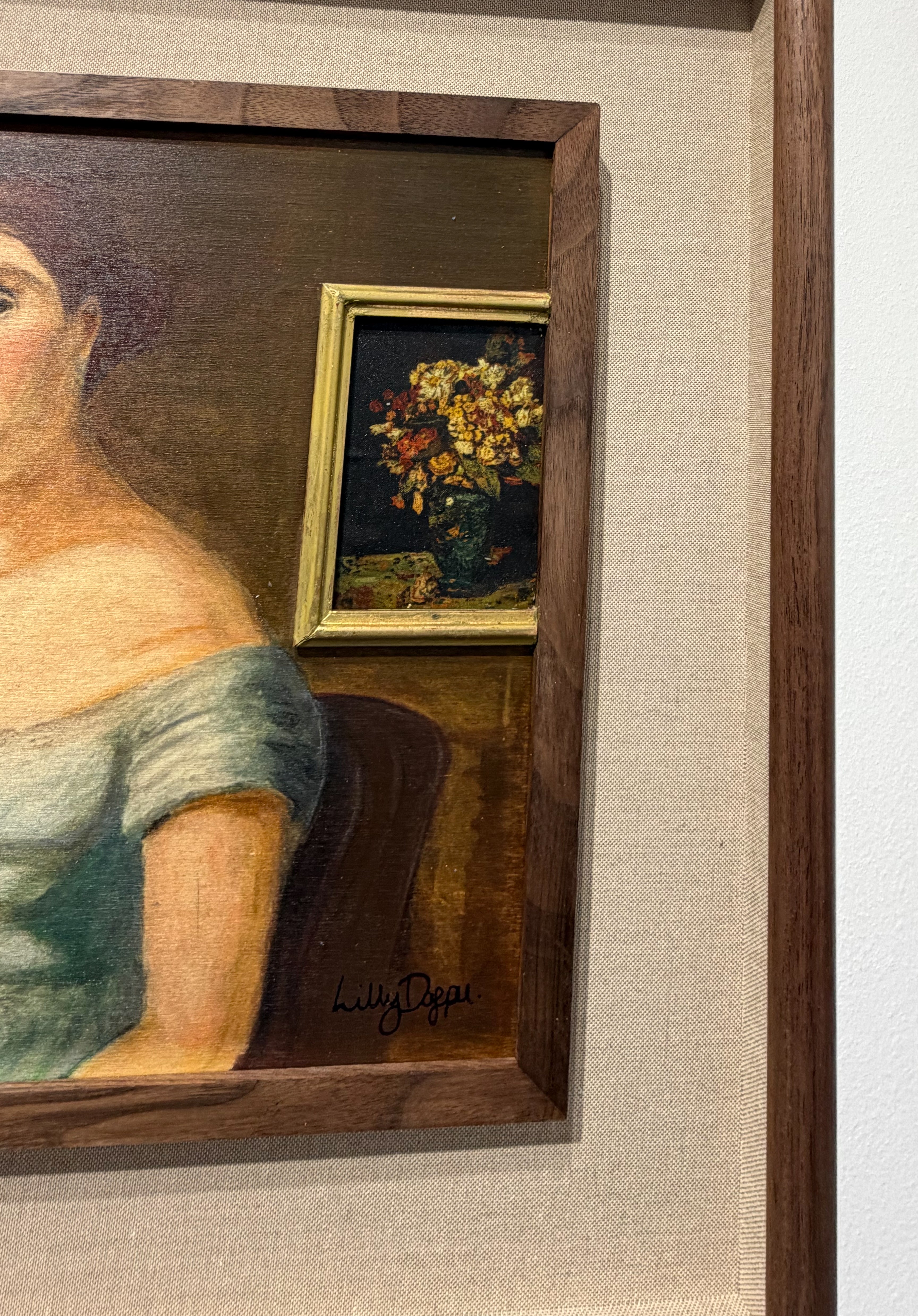 Framed portrait with a smaller inset of flowers on a textured wall.
