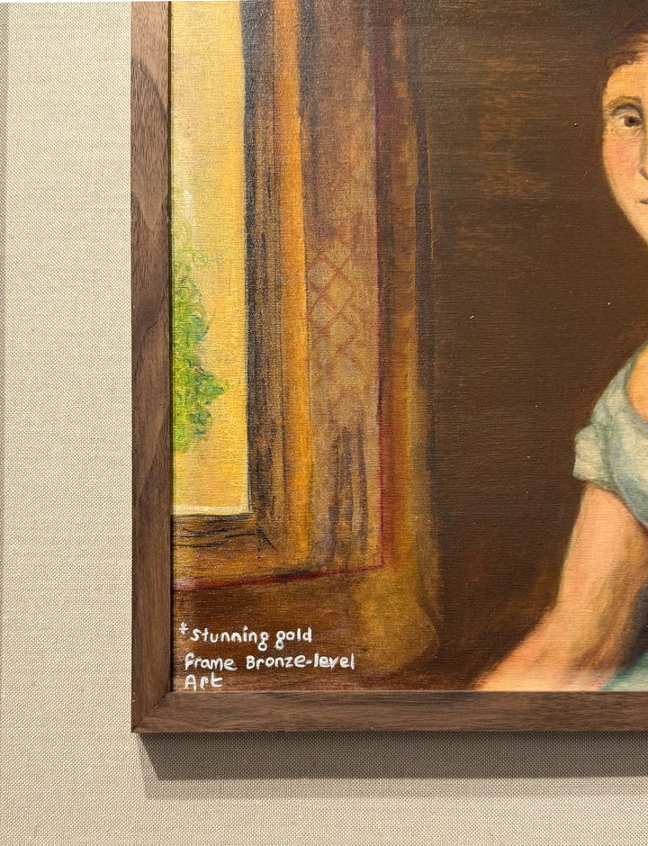 Close-up of a painting "Bronze Level", by Lilly Daffu  with a wooden frame and text on a textured surface.