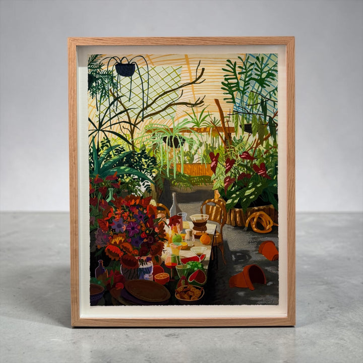 A framed art print featuring a whimsical, colorful illustration of a garden party scene, displayed in a light wood frame on a neutral gray background.