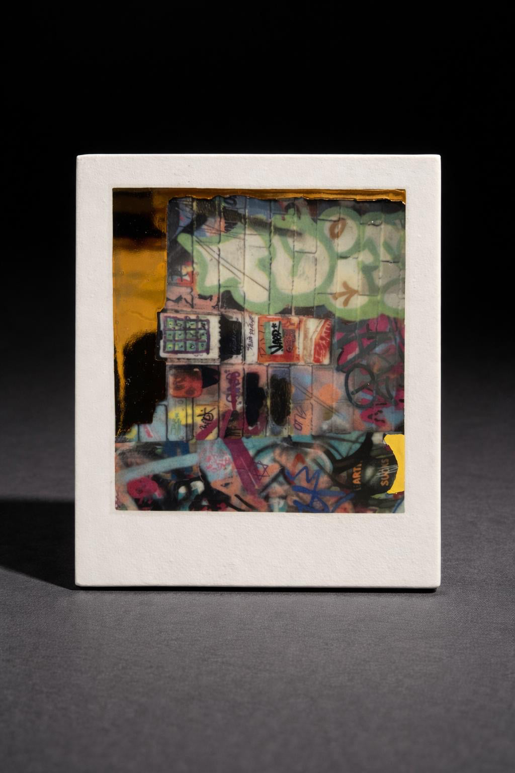 Framed abstract artwork with geometric shapes and colors on a dark background