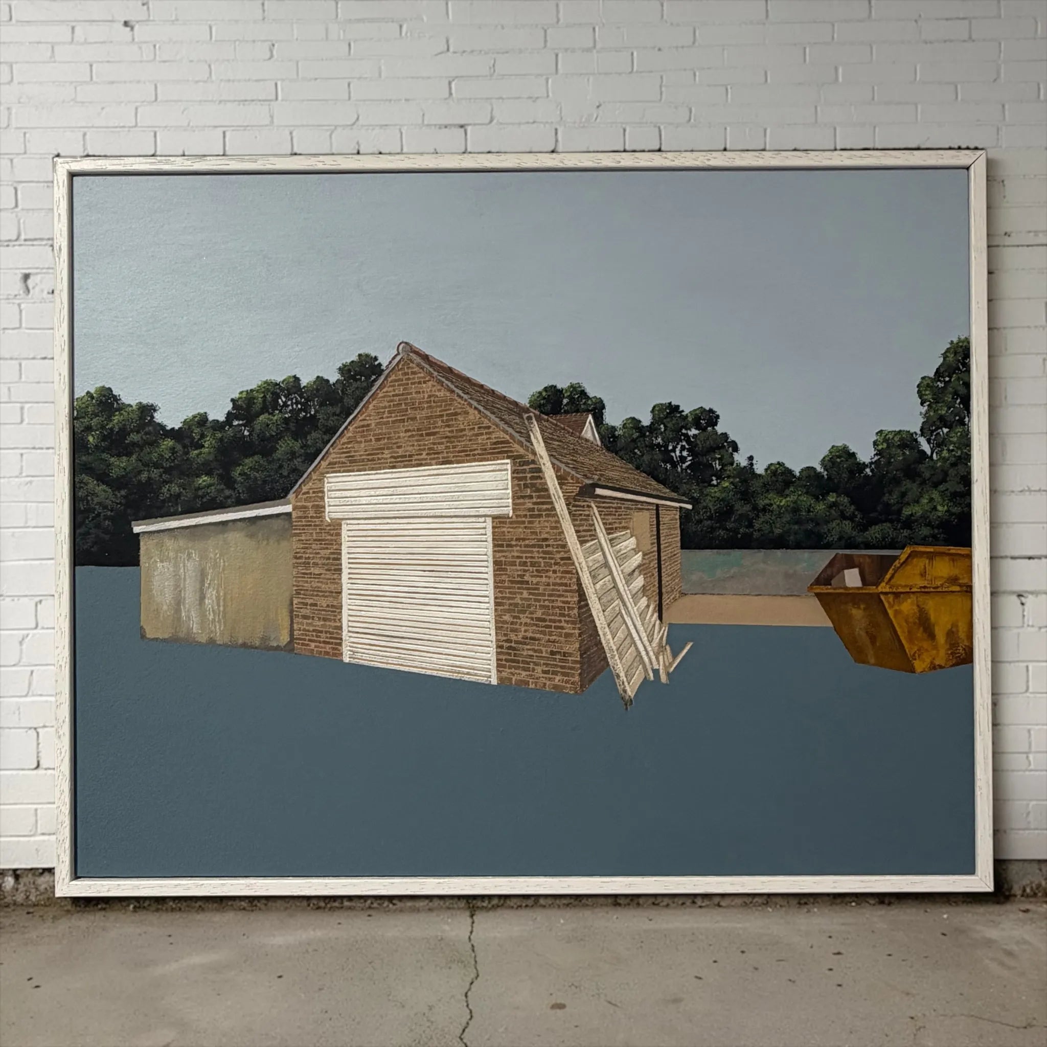 Framed artwork of a two-story building with a garage door against a blue sky and trees.