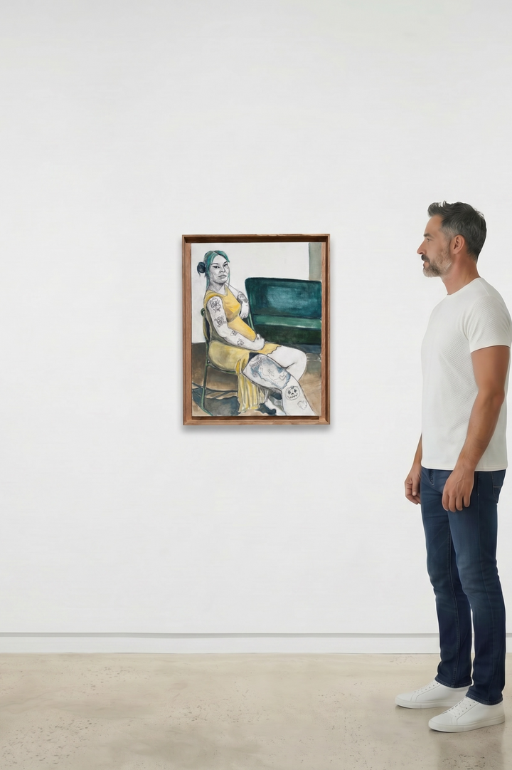 A man in a white t-shirt and blue jeans stands in a gallery room looking at a framed painting of Olivia by Juan Manrique.