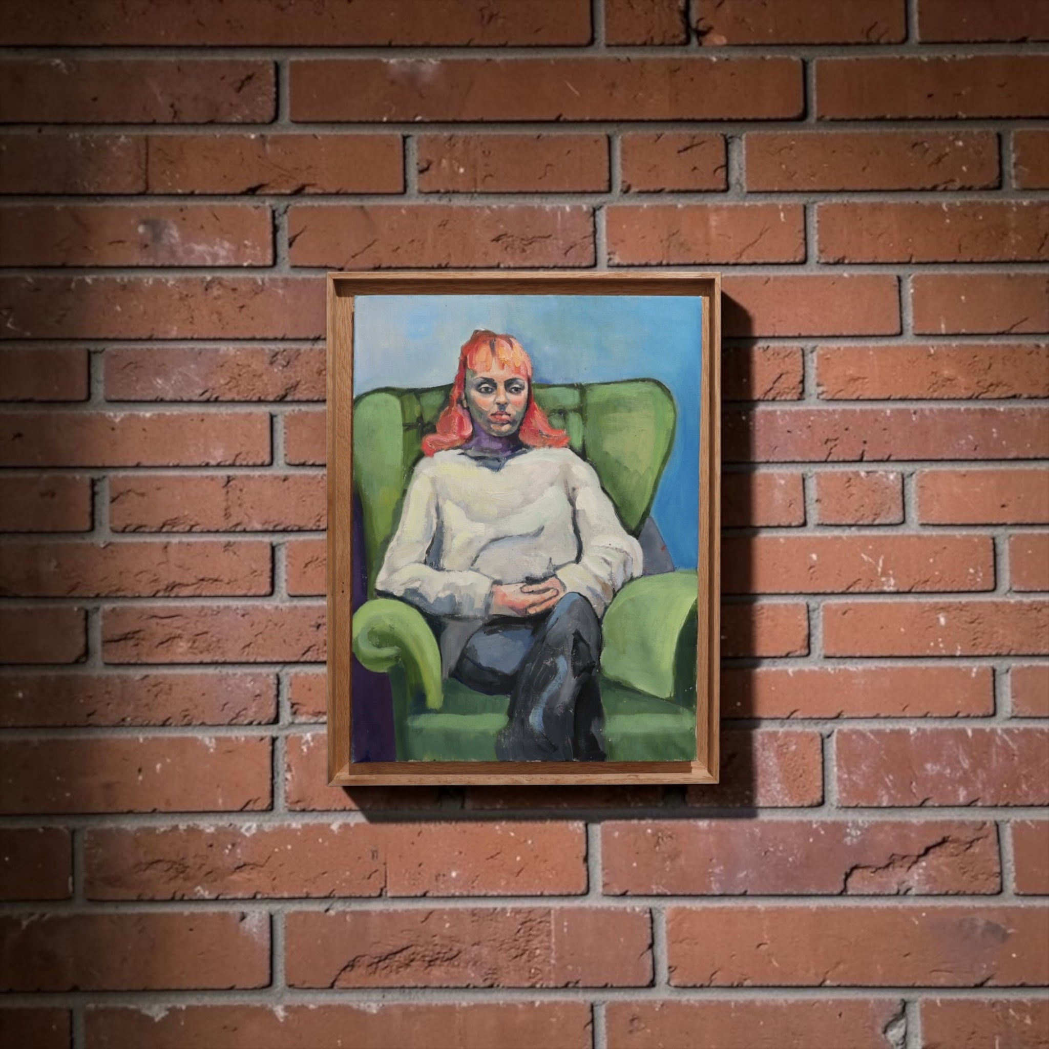 A framed painting of a seated figure in a green armchair against a blue background, hung on a red brick wall.