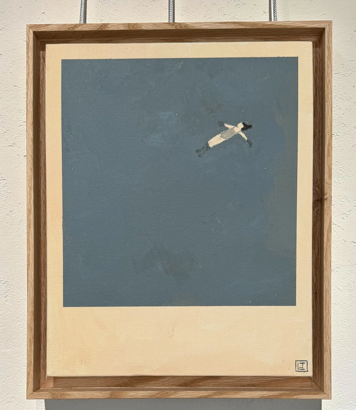 Framed artwork of a person floating on water against a blue background