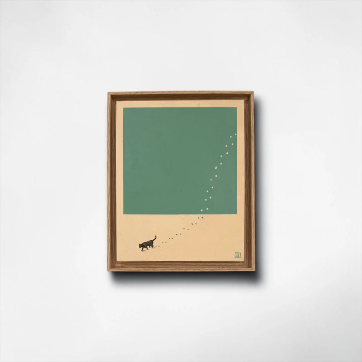 Framed artwork with a minimalist design of a cat and paw prints on a green paint and beige background.