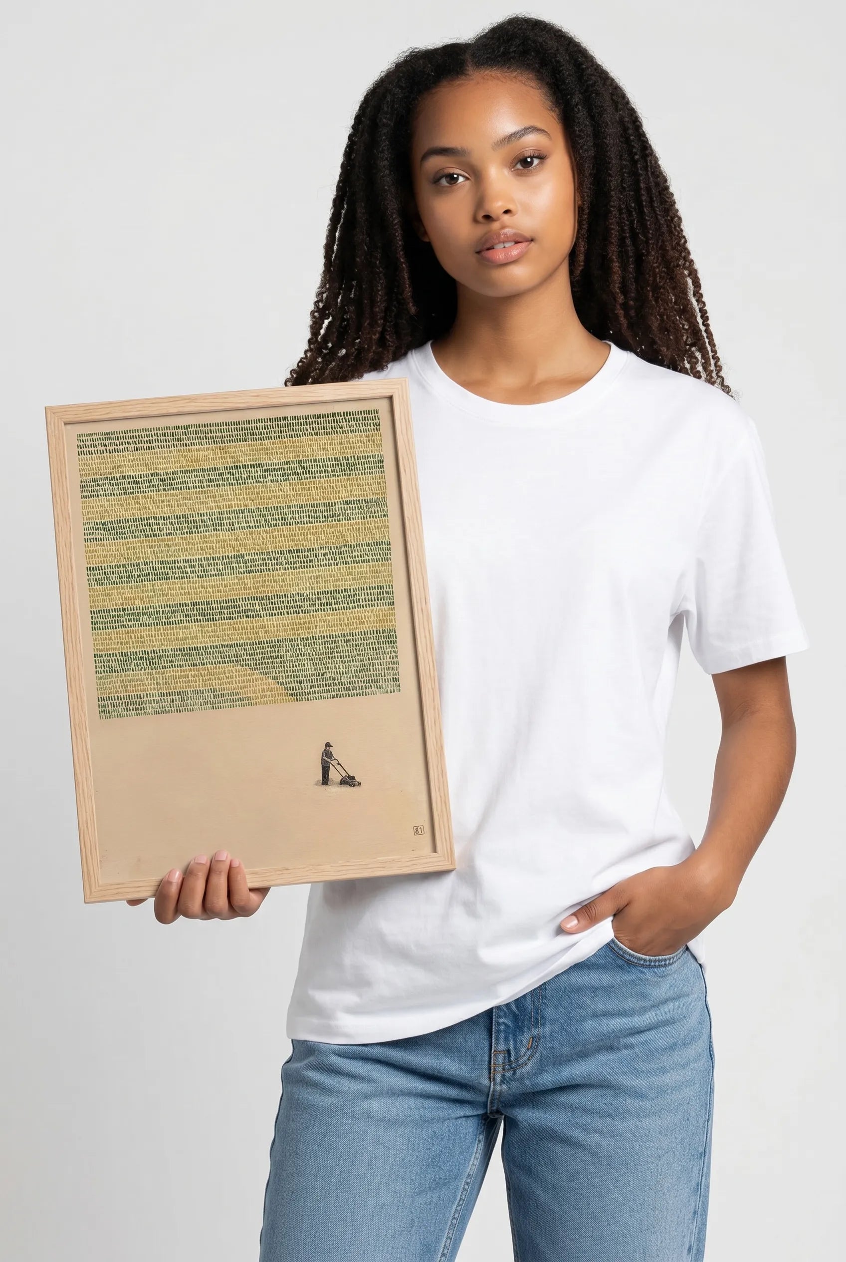 Person holding a framed artwork against a plain background