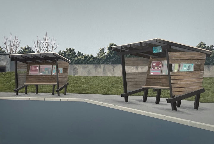 Two modern wooden bus stop shelters with integrated benches, set on a paved area next to a body of water, with a grassy field and trees in the background.