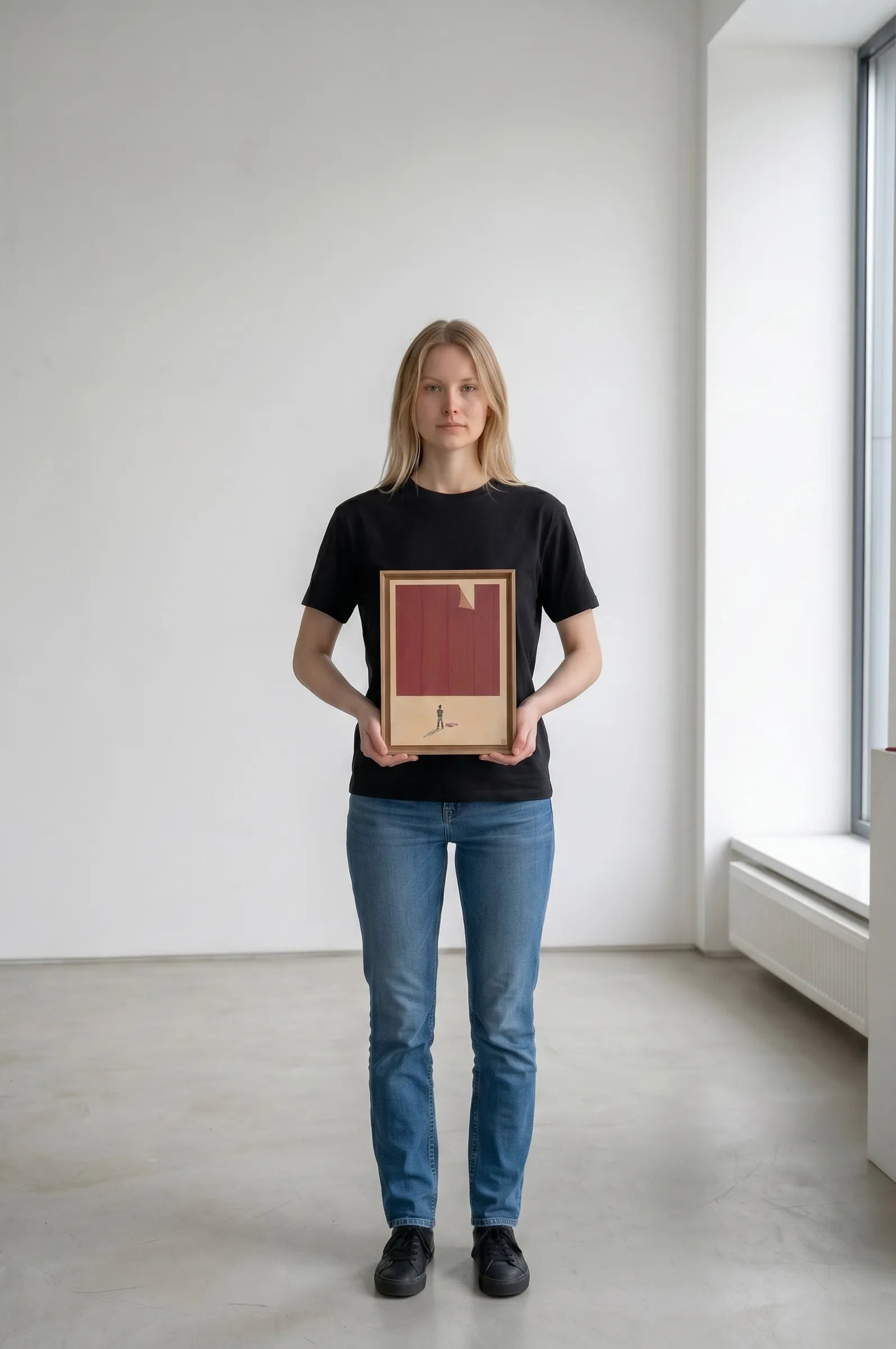 Person holding a framed artwork in a minimalistic room