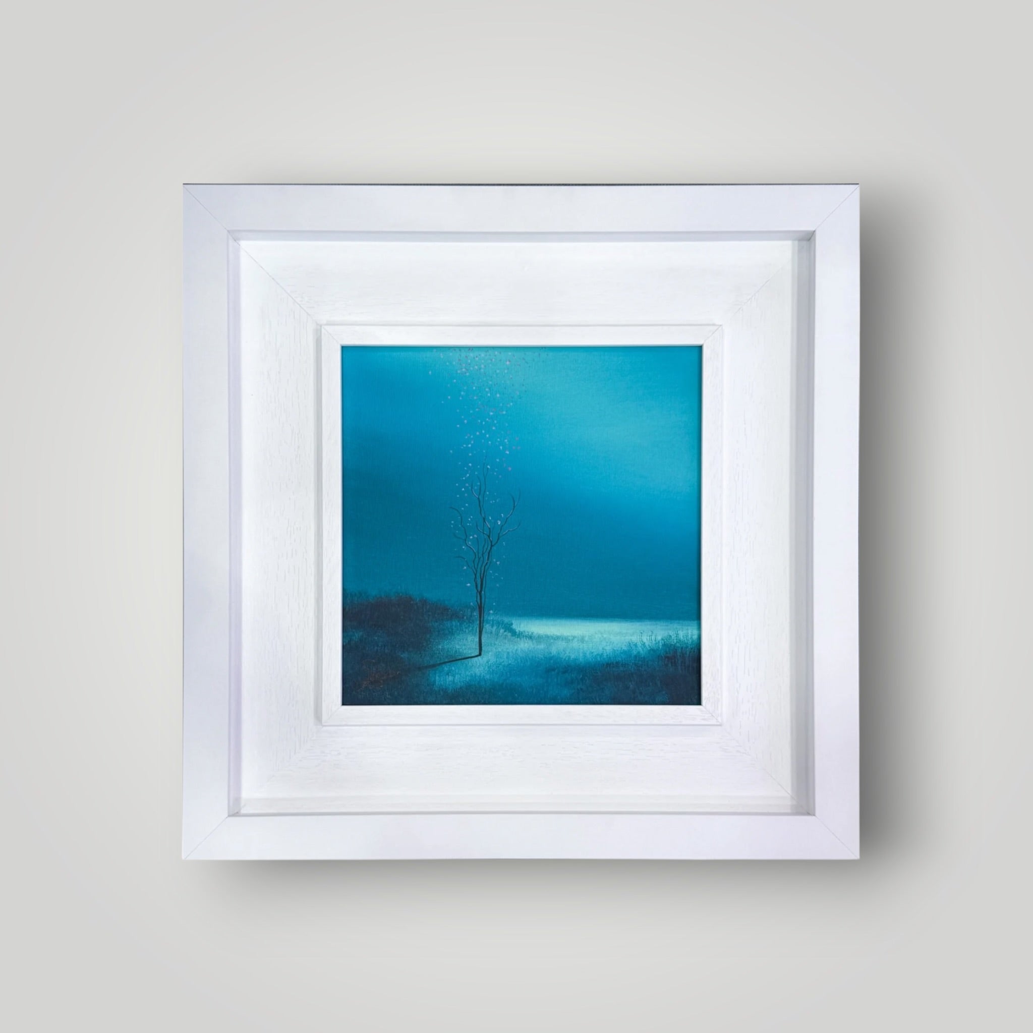 Original surrealist painting “Falling Blossom” by Vincent Devine, featuring a solitary tree with pink petals against a deep blue atmospheric background, in a white gallery frame.
