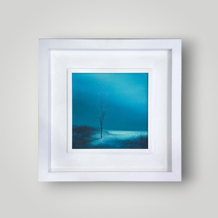 Original surrealist painting “Falling Blossom” by Vincent Devine, featuring a solitary tree with pink petals against a deep blue atmospheric background, in a white gallery frame.
