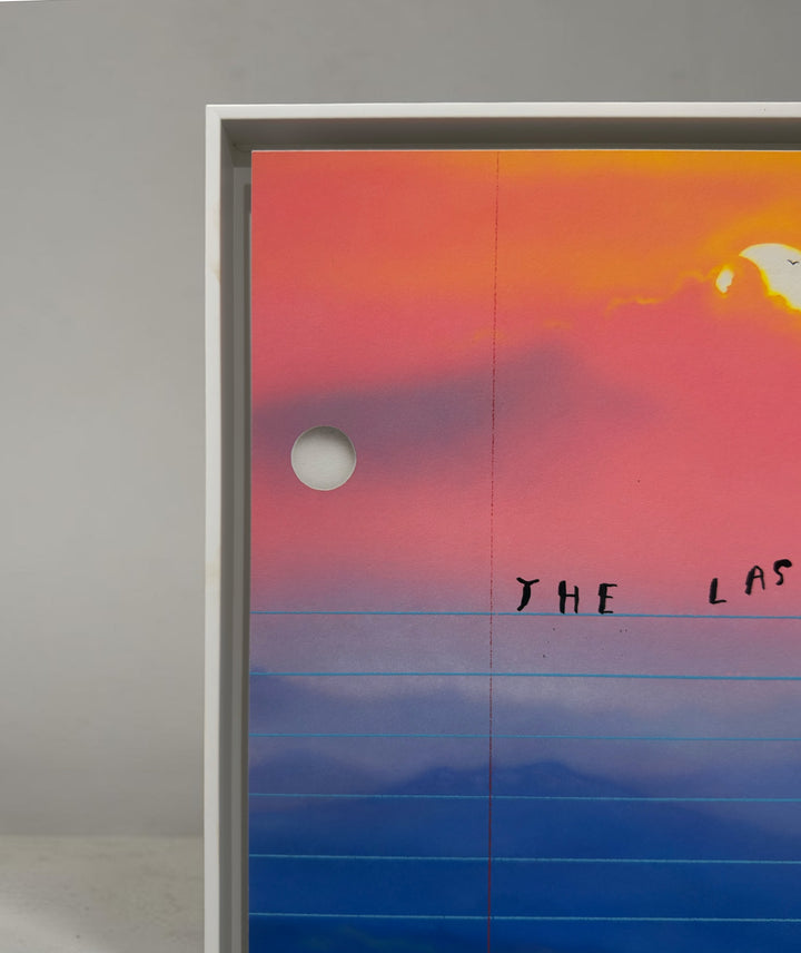 Close up corner of a framed artwork, orange sunset and blue sky on lined paper with blue and orange hues. Limited edition art print of The Last Perfect Day by Friedrich Kunath, featuring a surrealist landscape with a vibrant sunset and poetic themes, high-quality archival giclée print.