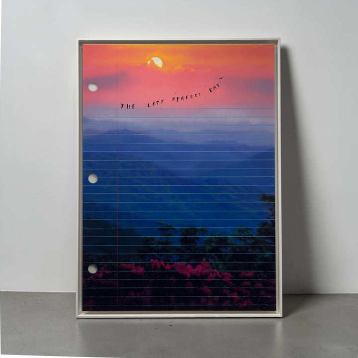 Framed artwork of a sunset over mountains, blue and orange hues with 'The Last Perfect Day' text. Limited edition art print of The Last Perfect Day by Friedrich Kunath, featuring a surrealist landscape with a vibrant sunset and poetic themes, high-quality archival giclée print.