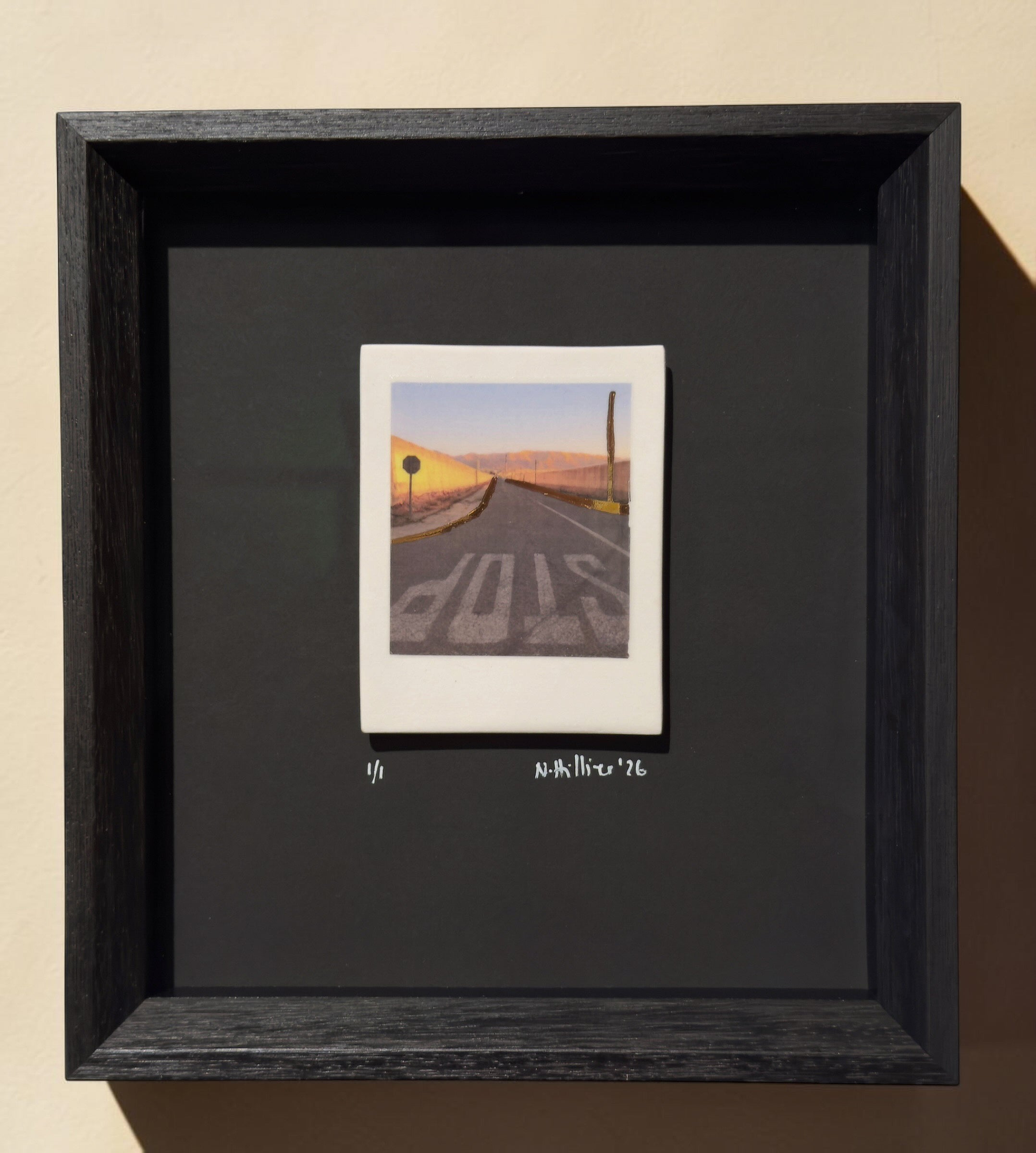 Framed incised photographic ceramic decal on porcelain titled "Nowhere Town" by artist Nadia Hillier, featuring a road scene with a "STOP" sign and real gold application