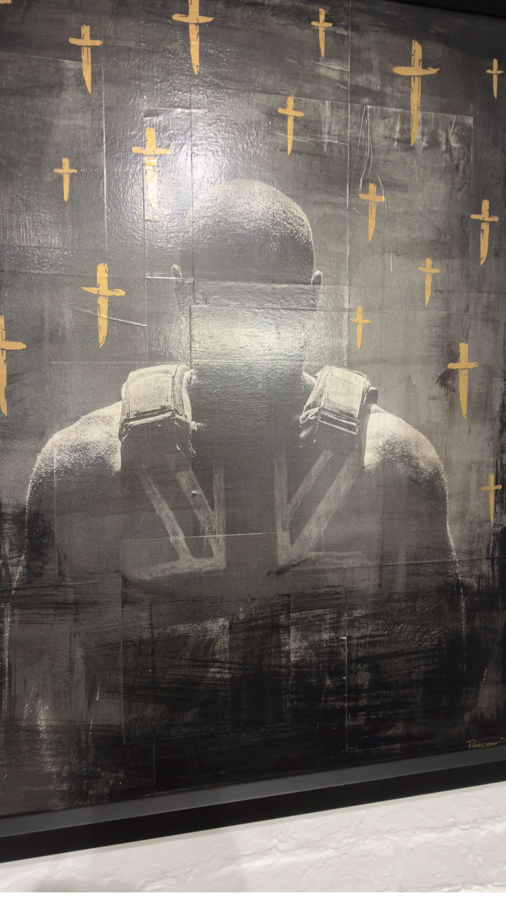 Mixed media artwork titled "Still Time" by Percent featuring nineteen blades and Stormzy in a stab vest, displayed in a black frame, angled picture.